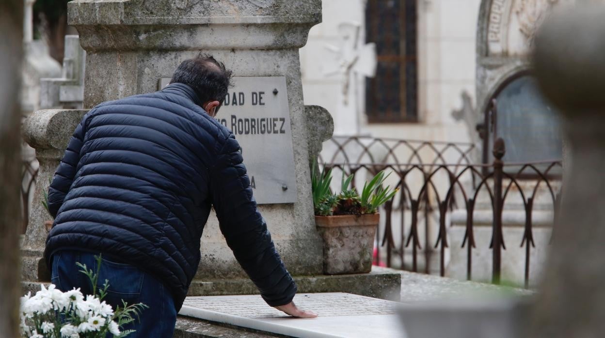 Un hombre posa un beso sobre la tumba de un allegado en el cementerio del Carmen, en Valladolid