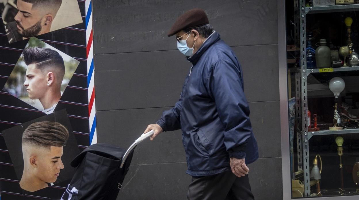 Imagen de archivo de un hombre paseando con mascarilla en Alicante