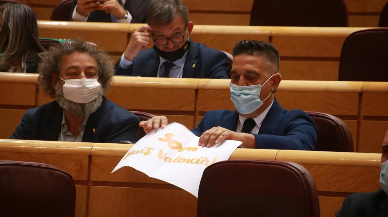 Imagen del senador de Compromís Carles Mulet con un cartel que reza «Som País Valencia»