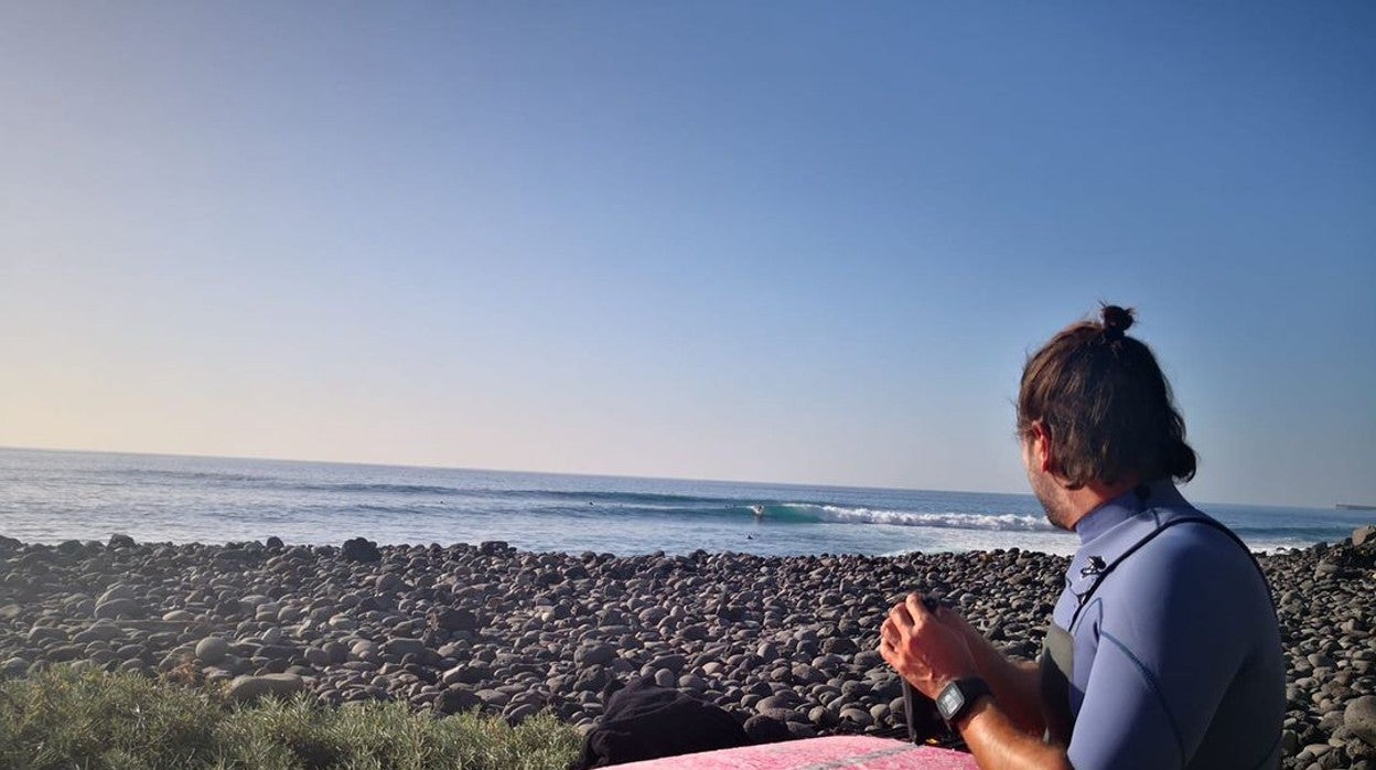 Un surfero se prepara para entrar al agua en la playa de Los Guirres