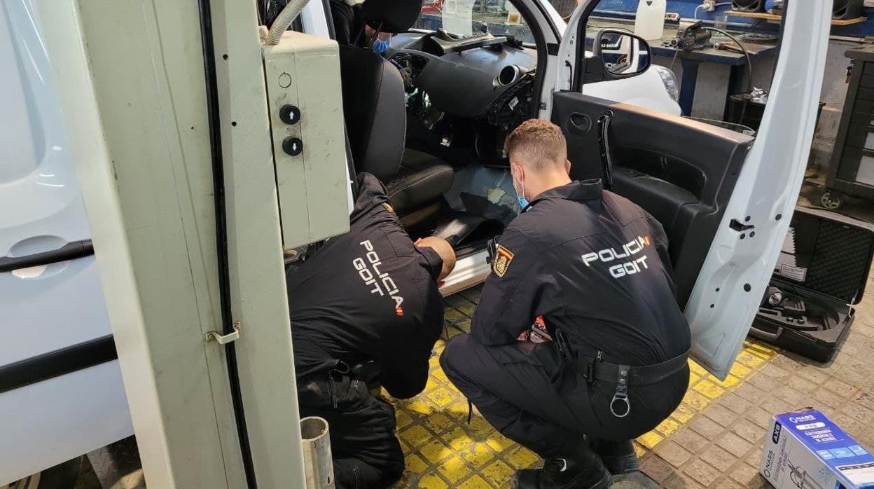 La banda operaba con una amplia flota de vehículos preparados para ocultar la droga. En la imagen, dos agentes ante una de las furgonetas