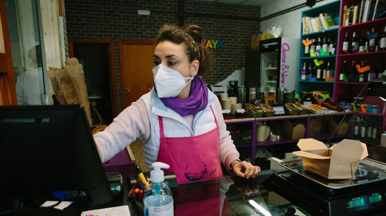 Una comerciante cobra una compra en caja