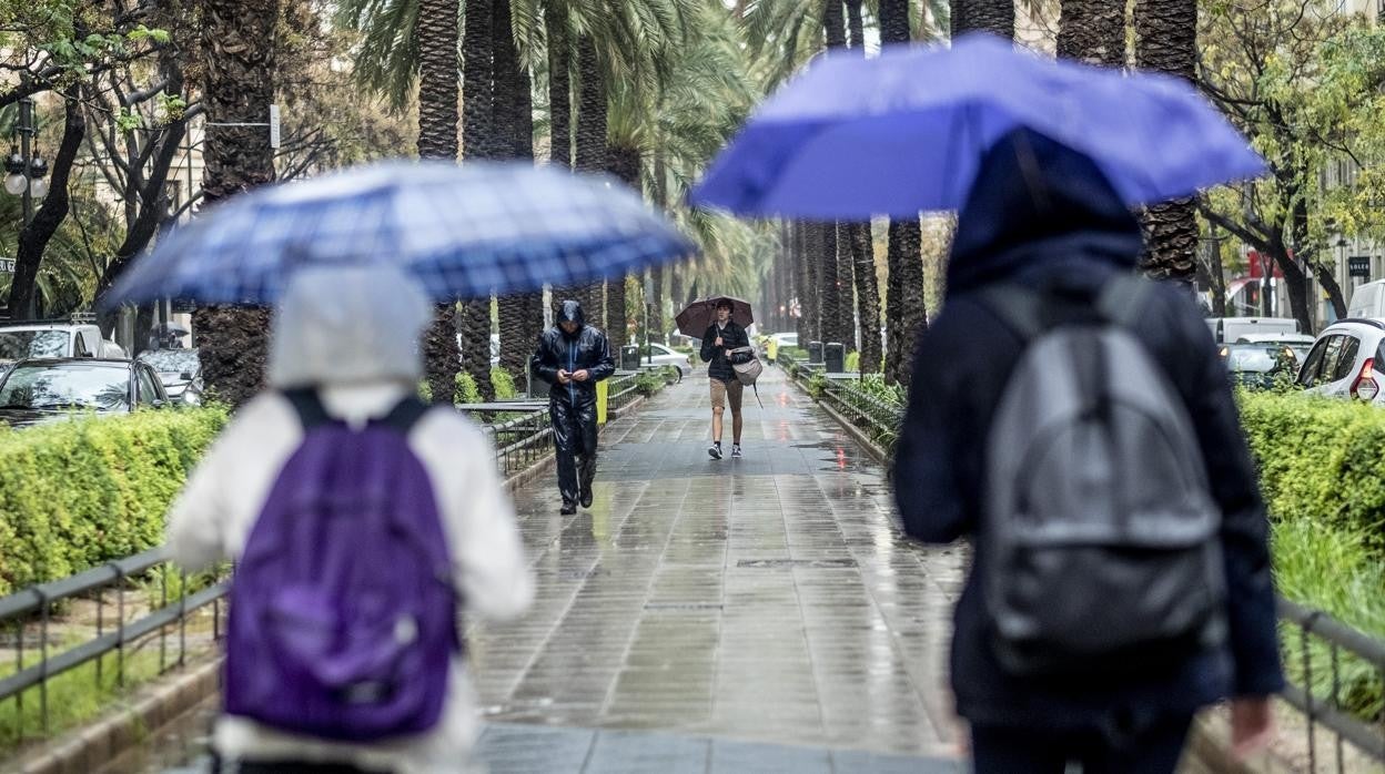 Imagen de archivo de varias personas paseando por Valencia durante un día lluvioso