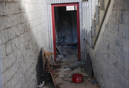 Uno de los cuartos de baño, al fondo, totalmente destrozado