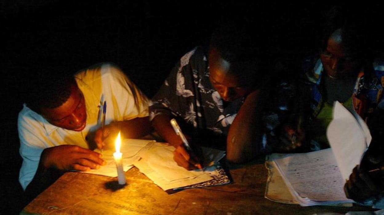 Dos hombres toman notas a la luz de las velas
