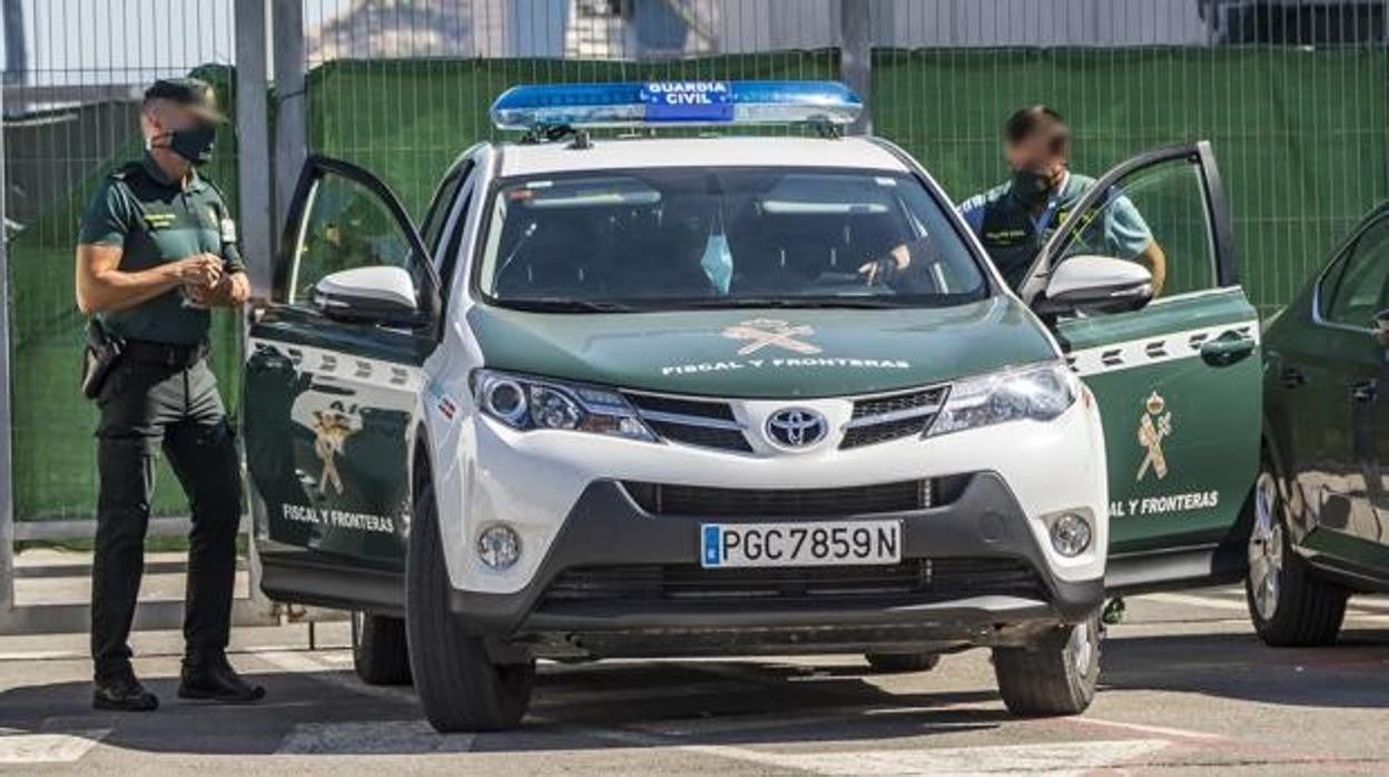 Imagen de archivo de dos agentes de la Guardia Civil junto a su coche patrulla