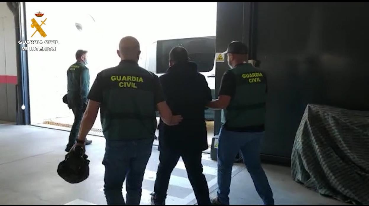 Uno de los detenidos, custodiado por la Guardia Civil