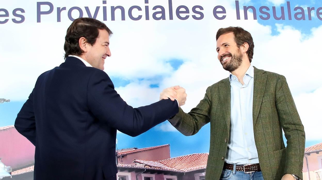 El presidente nacional del PP, Pablo Casado (d) saluda al presidente autonómico, Alfonso Fernández Mañueco