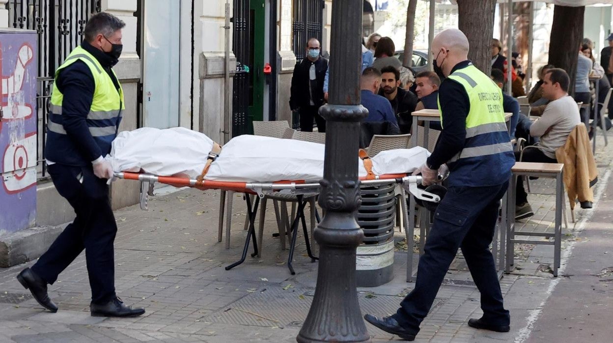 Operarios del retén fúnebre sacan el cadáver de la mujer de treinta años asesinada en Valencia