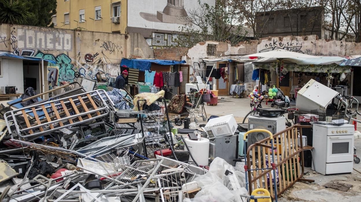 La pequeña Ionela asoma la cabeza tras la verja de la gasolinera ocupada en la que vive junto a sus padres
