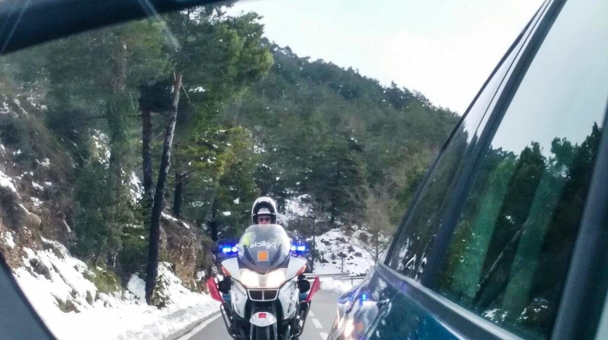 Un motorista de la unidad de tráfico policía catalana, junto a un turismo