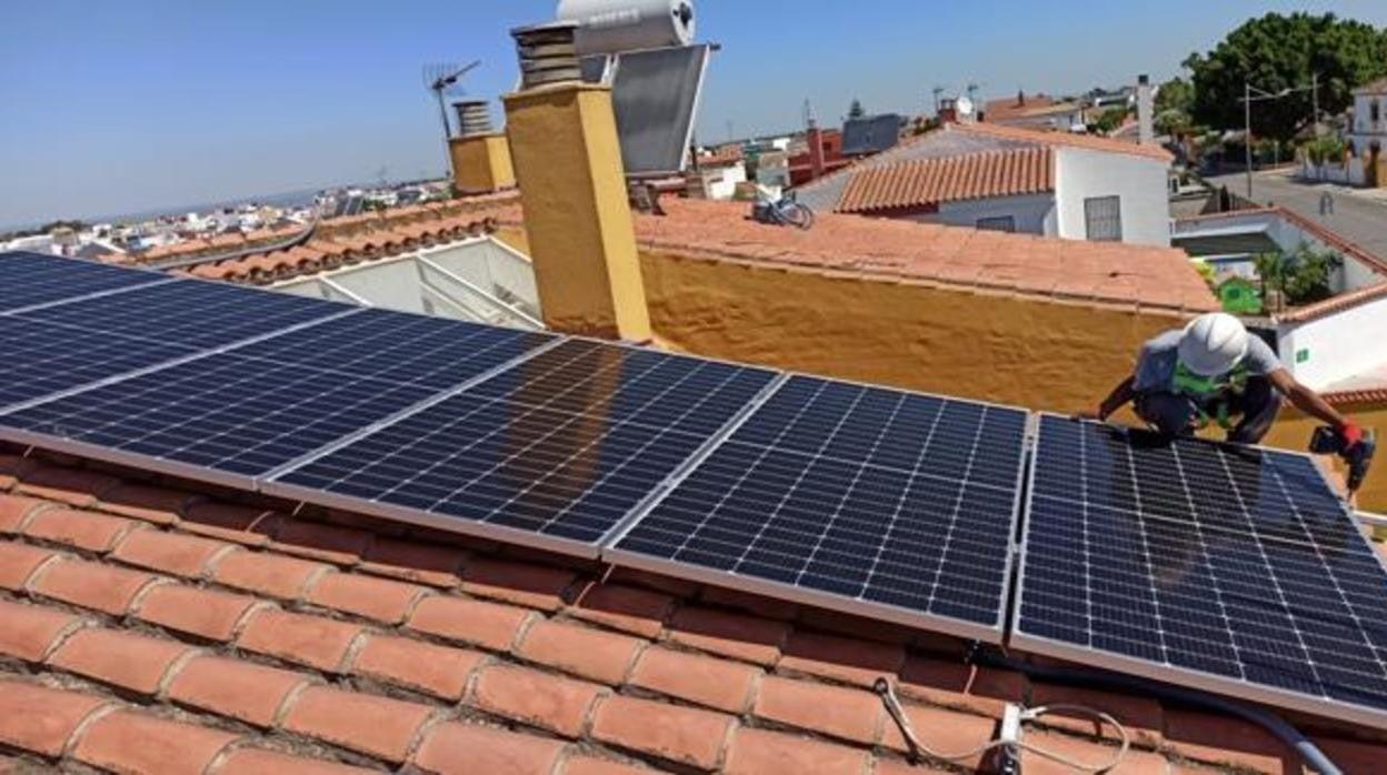 Un instalador coloca paneles solares para autoconsumo en una vivienda