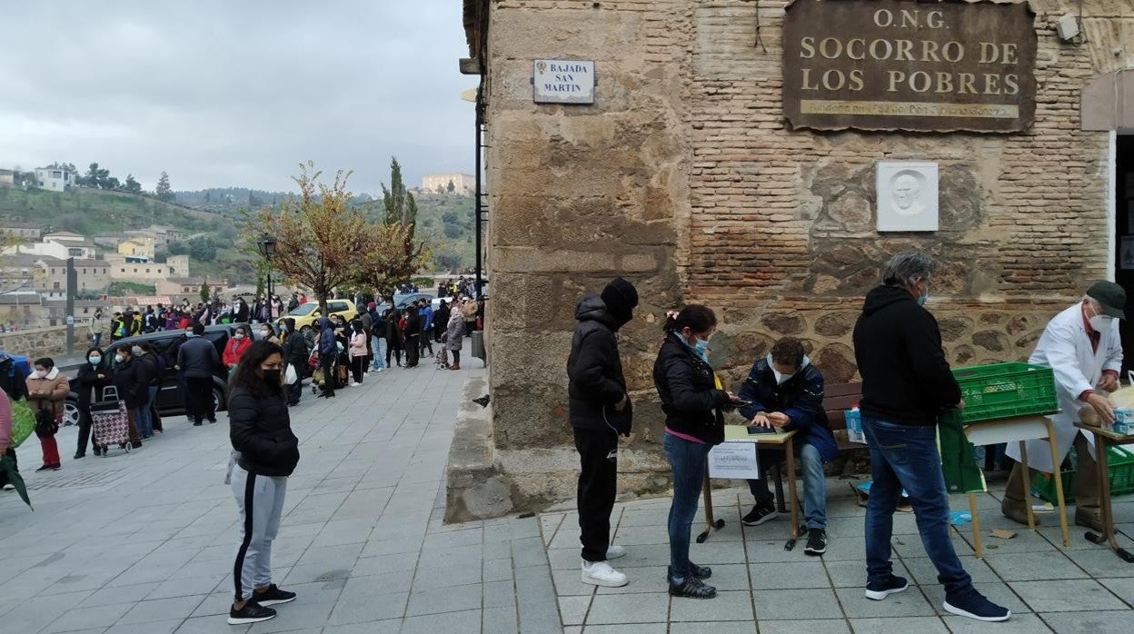 Personas hacen fila delante de la sede de la ONG Socorro de los Pobres