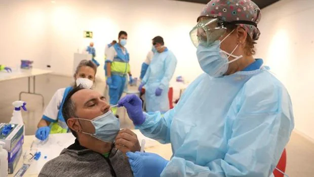 Una trabajadora sanitaria le realiza un test de antígenos a un hombre