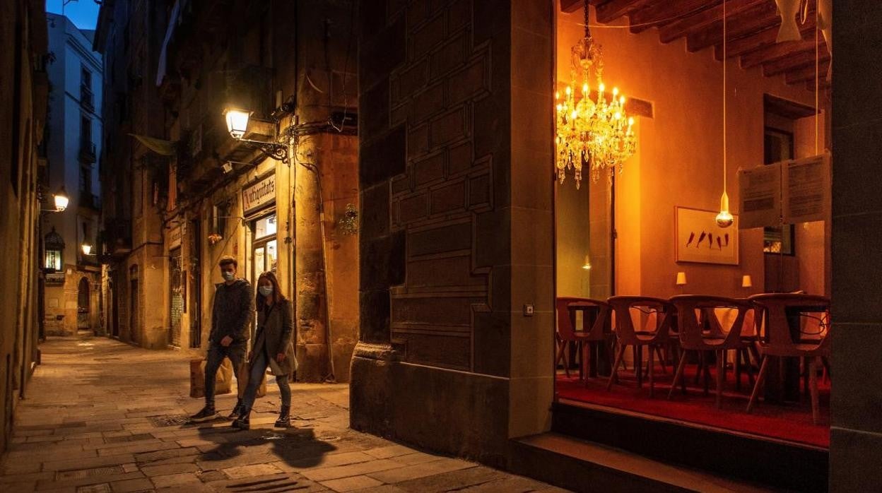 Dos personas pasean por Barcelona minutos antes del toque de queda