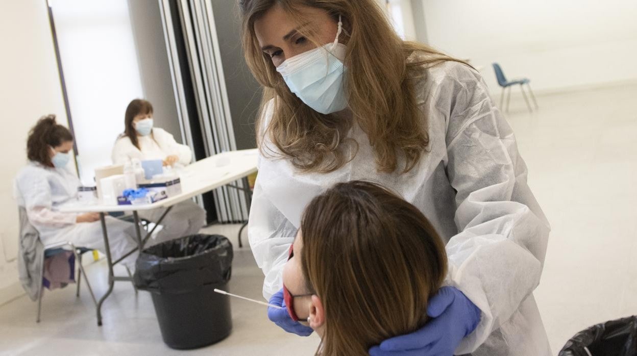 Una sanitaria realiza un test de antígenos a una mujer