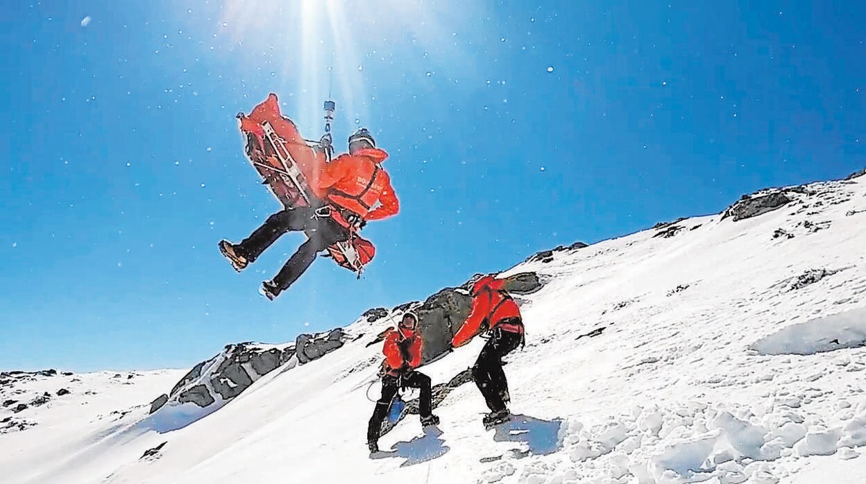 Tres efectivos del GERA suben en camilla a una persona accidentada en una zona de nieve