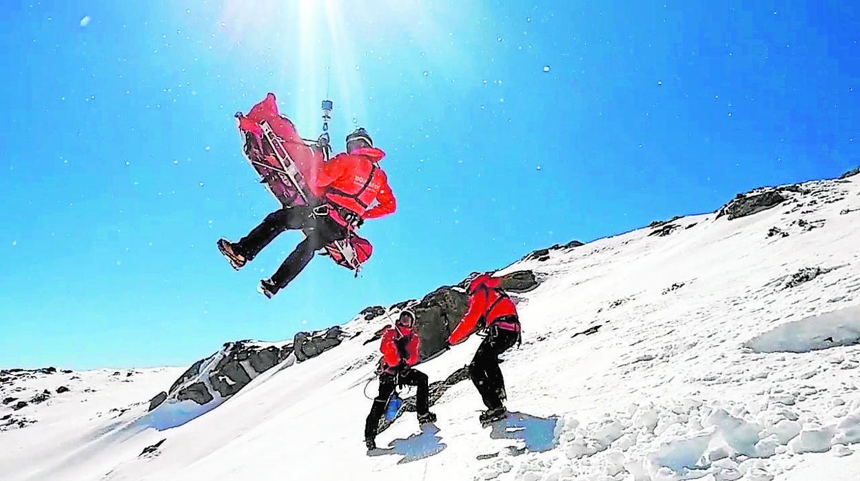 Tres efectivos del GERA suben en camilla a una persona accidentada en una zona de nieve