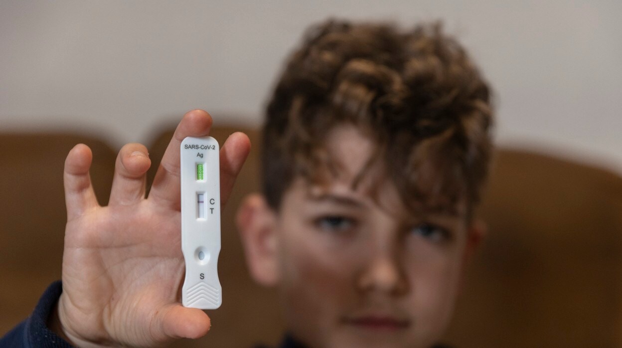 Un niño muestra un test de antígenos negativo en Covid-19