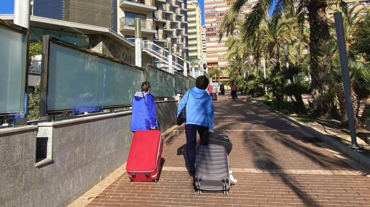 Dos turistas arrastran sus maletas en Benidorm