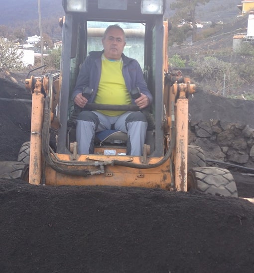 Juan, con su pala mecánica, limpia de ceniza el Camino La Lajita