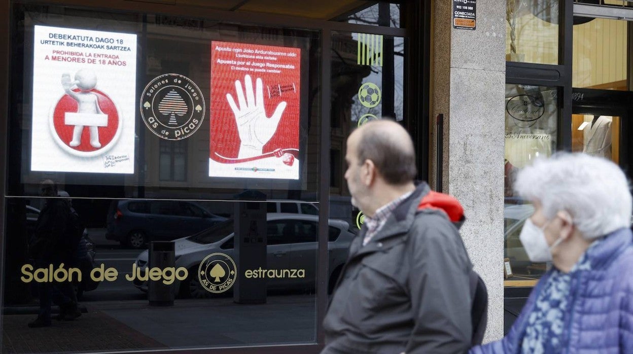 Dos personas pasean junto a un salón de juego en Bibao