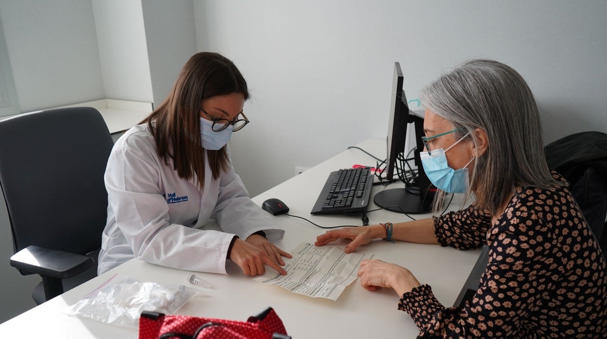 Una doctora del Vall d'Hebron con una paciente y sus muestras de saliva