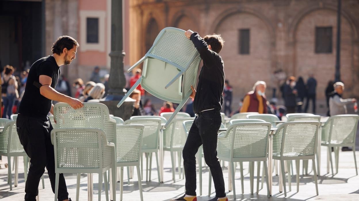 Imagen de dos camareros preparando una terraza de un restaurante en el centro de Valencia