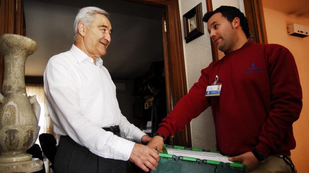 Un hombre recibe la compra en casa gracias al Servicio de Ayuda a Domicilio municipal