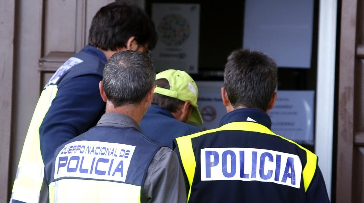 Agentes de policía trasladan a un detenido en un caso de archivo