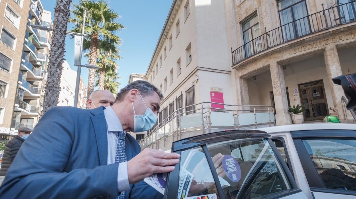 Francisco Tierraseca coloca una de las pegatinas violetas en un taxi