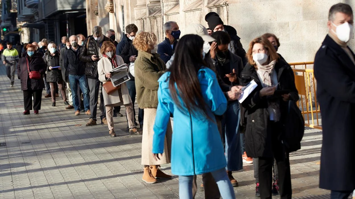 Varias personas haciendo cola para vacunarse ante la sede de Casa Seat en Barcelona