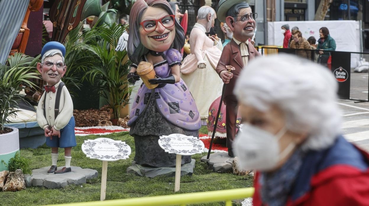 Imagen de una mujer con mascarilla por el coronavirus visitando una falla de Valencia