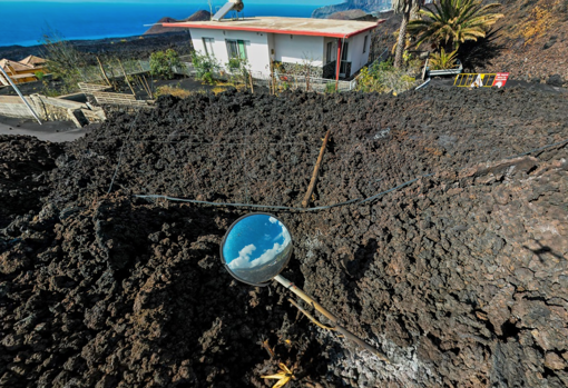 Una casa y un espejo de señalización de tráfico al borde de la colada