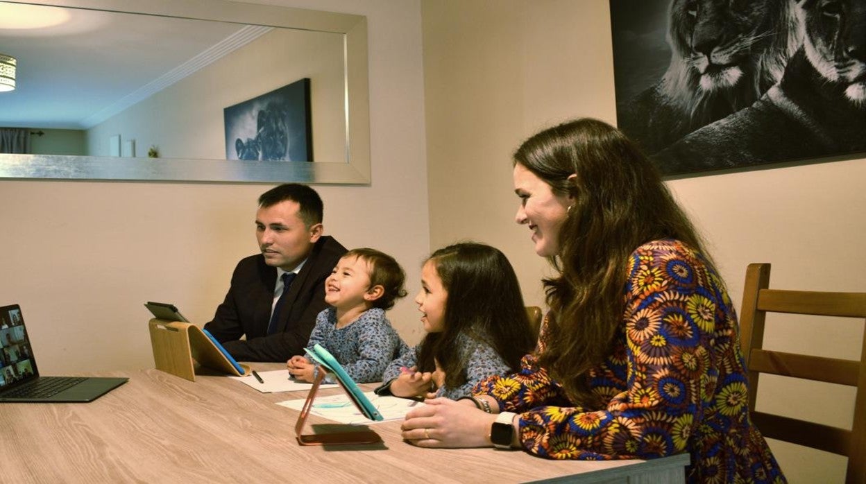 Una familia de testigos se conecta por videoconferencia a una reunión de la congregación