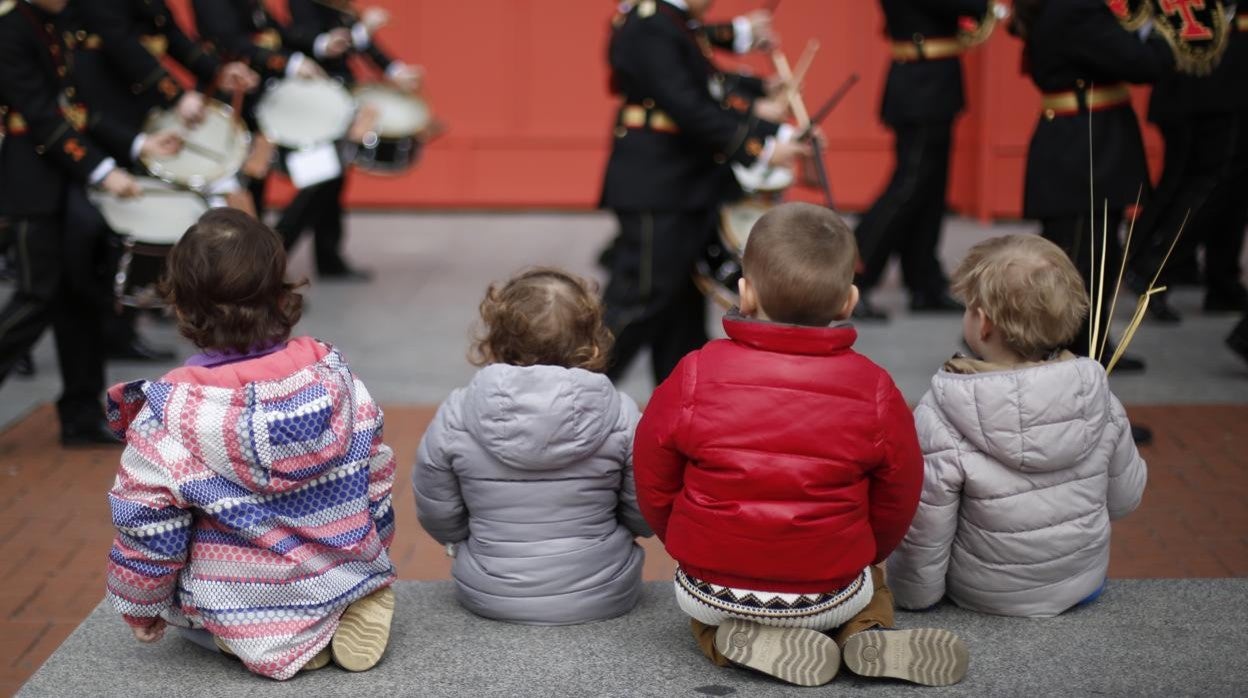 Niños contemplan el paso de la procesión del Domingo de Ramos en Valladolid