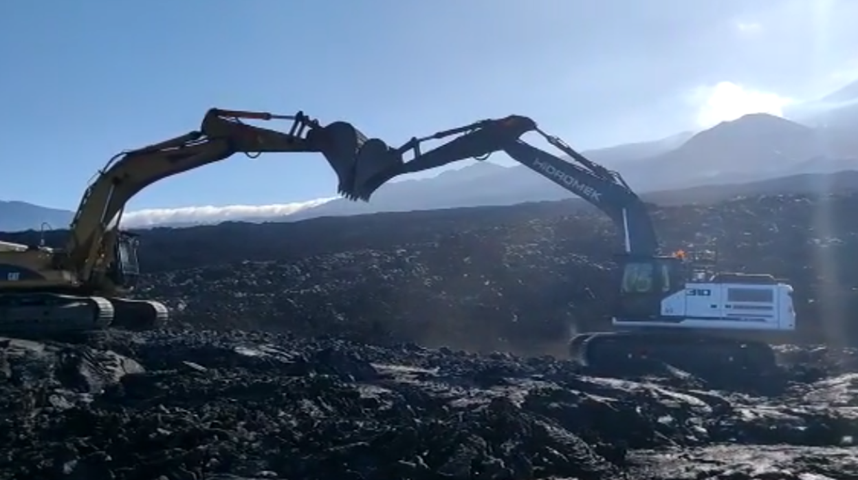 Las retroexcavadoras que trabajan en los caminos sobre la lava se unen