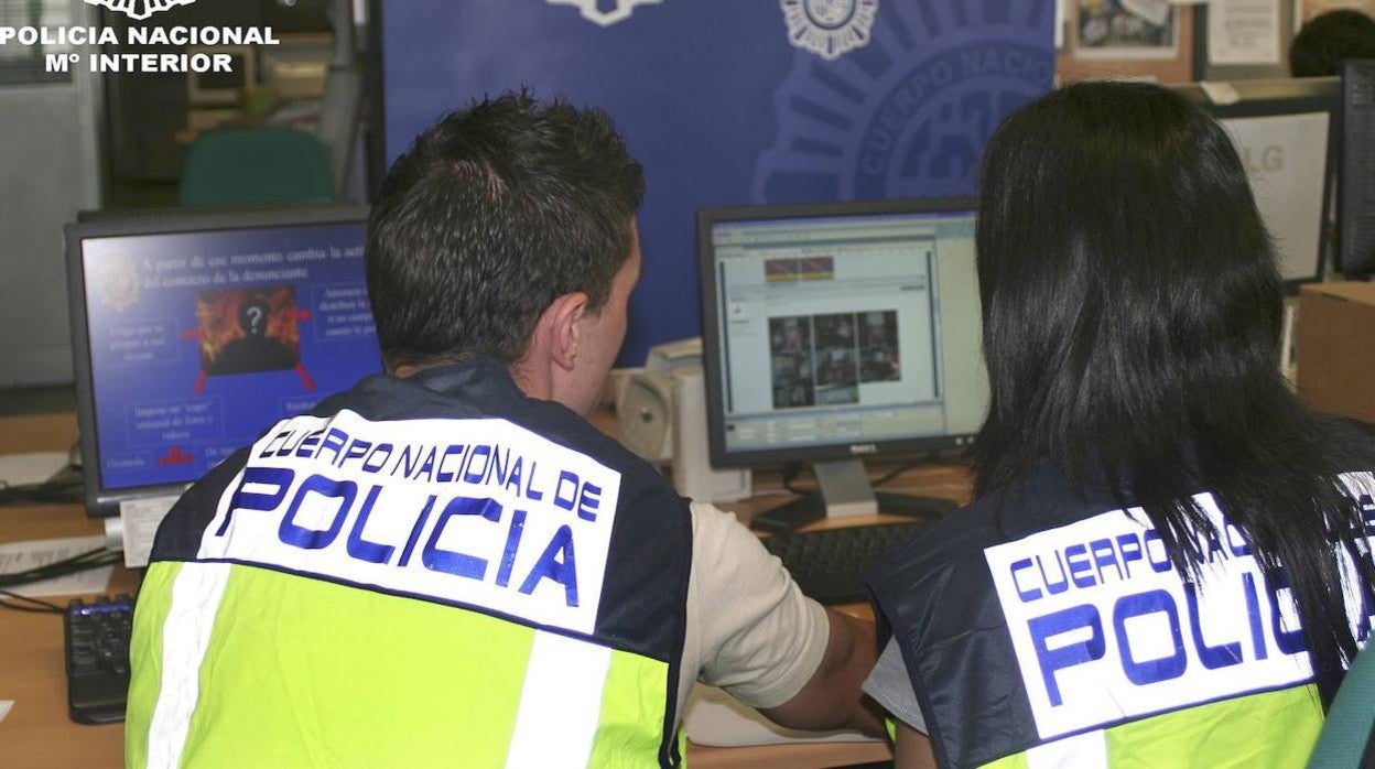 Dos agentes revisan un ordenador en una investigación para esclarecer un ciberdelito