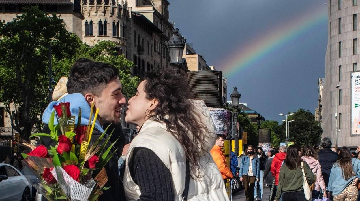 Dos jóvenes se besan en el centro de Barcelona tras la tormenta que ha azotado Sant Jordi