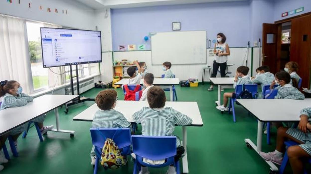 Varios niños escuchan las explicaciones de su profesora en una clase del colegio Virgen de Europa