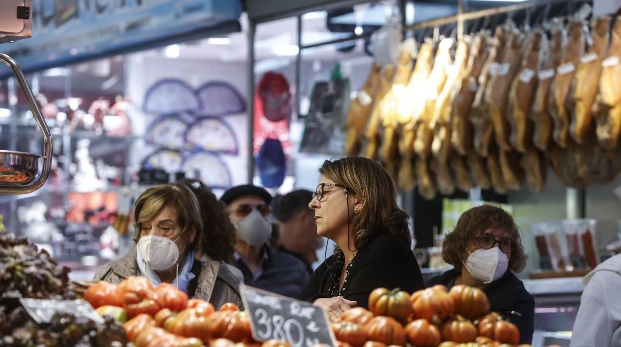 Imagen de archivo de personas con y sin mascarilla en un mercado de Valencia