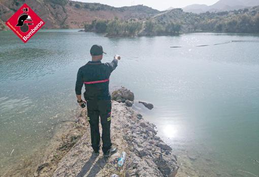 Un bombero señala la zona en la que fue visto el nadador