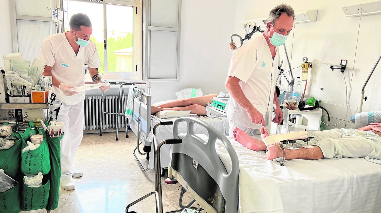 El teniente coronel Juan José Sevilla Tirado, jefe de Traumatología del Hospital General de la Defensa de Zaragoza, junto a un piloto herido en Ucrania