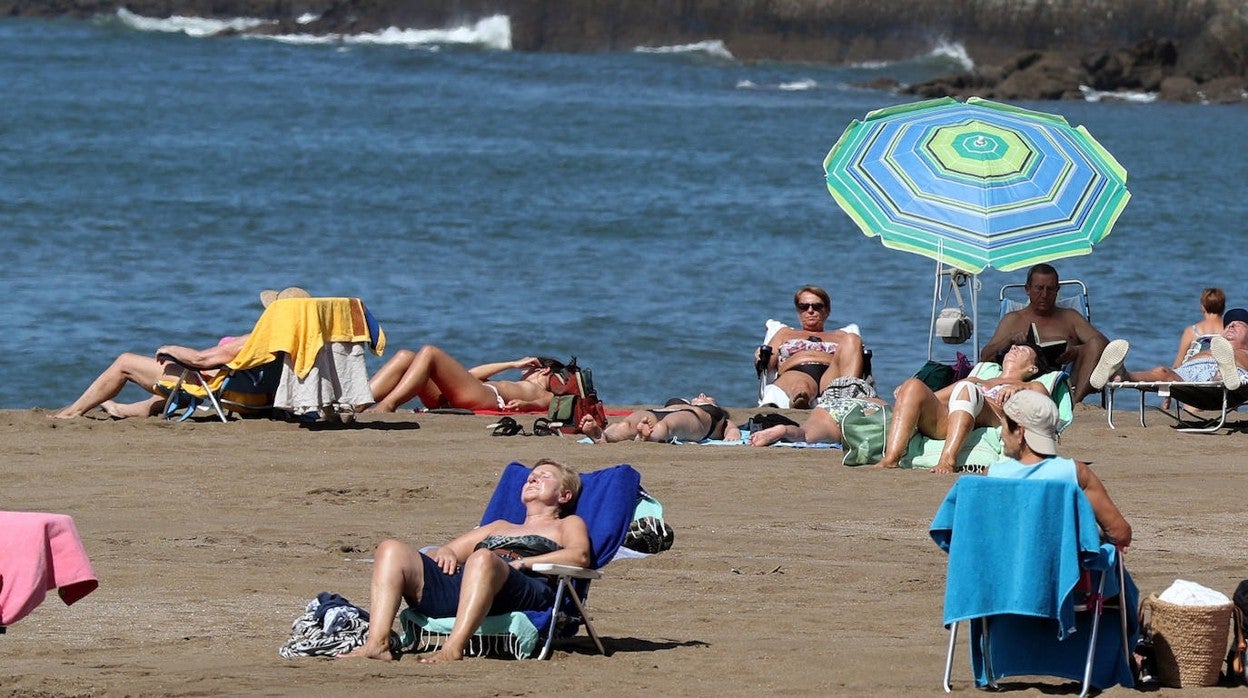 Varias personas disfrutan del buen tiempo en la playa vizcaína de Ereaga