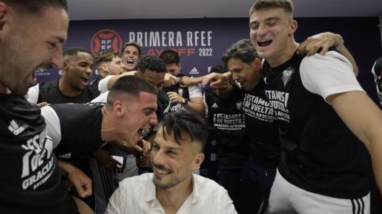 Rubén de la Barrera celebra con sus jugadores el ascenso en rueda de prensa