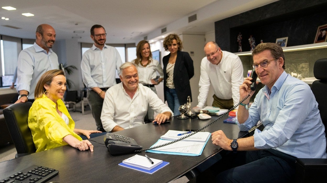 Alberto Núñez Feijóo habla con Juanma Moreno, junto a todo su equipo en Génova