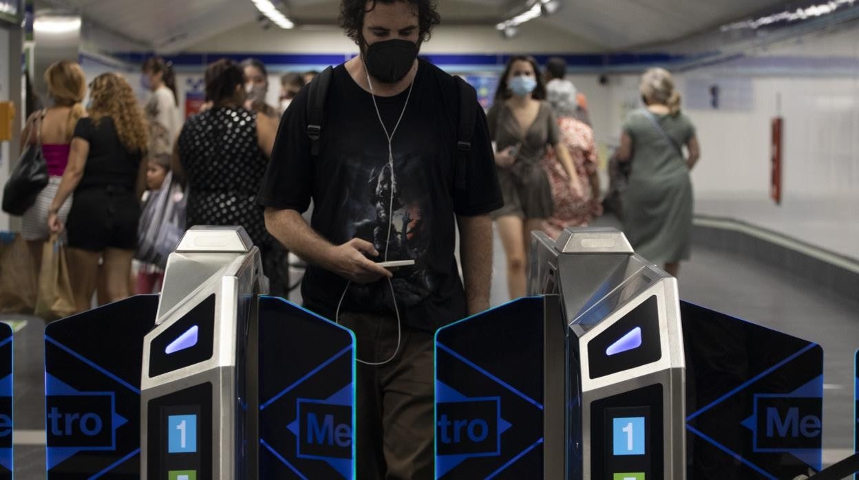 Viajeros en el metro de Madrid en la estación de Gran Vía