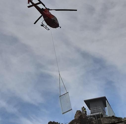 Un helicóptero porta los materiales de construcción de la torre