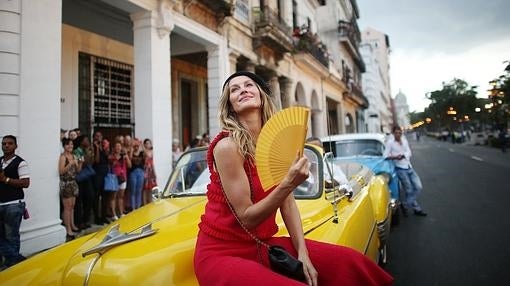 La modelo Gisele Bündchen posa sobre un almendrón cubano