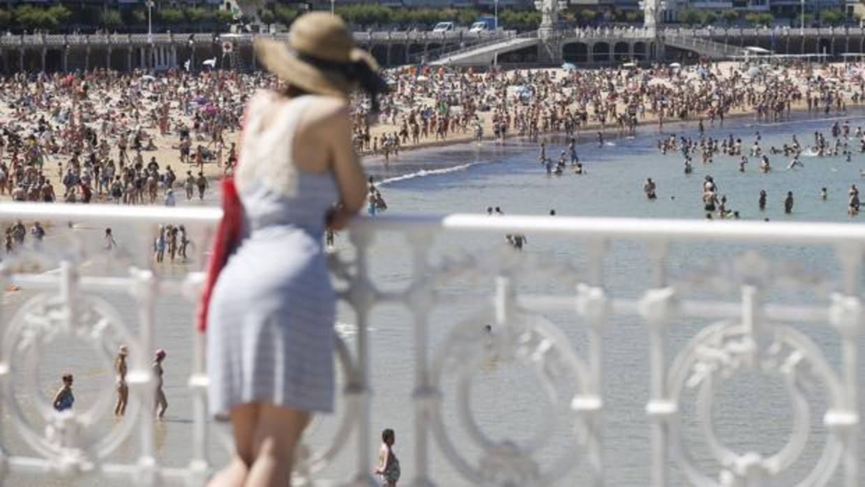 Un joven observa la playa de La Concha de San Sebastián,